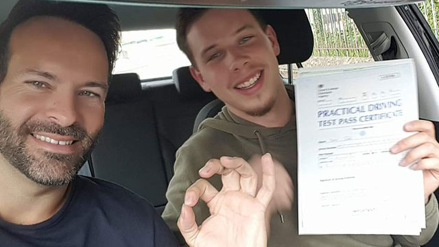 Learner showing their practical driving test pass certificate